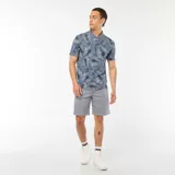 Remera polo de piqué de algodón color azul con estampado de hojas en blanco y negro.