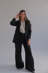 Pantalón de vestir negro de tiro alto, corte palazzo y pierna ancha.
