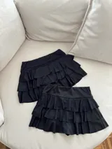 Minifalda negra con volados y short debajo.