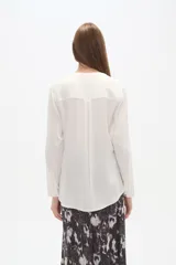 Blusa de viscosa con cuello mao y abertura frontal con botones. Presenta un estampado de rayas verticales finas en tonos azul claro, blanco, marrón y azul oscuro.