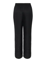 Pantalón negro de corte ajustado con tiro alto, fit relajado y detalle de strass en la parte inferior.