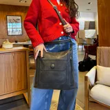 Cartera bandolera negra de símil cuero con doble cierre superior, bolsillo frontal con tapa y broche magnético, bolsillos laterales con cierre, correa larga regulable y desmontable.
