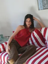 Top dorado de cuero con espalda de lino, corte irregular y cuello halter con detalle de un caballito.