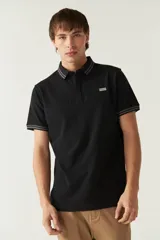 Remera cuello polo negra de manga corta con logo estampado y diseño en block con detalles en gris en cuello y mangas. Confeccionada en 100% algodón.