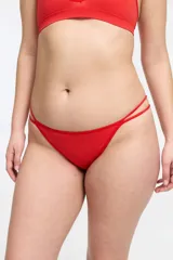 Conjunto de ropa interior color rojo, compuesto por un corpiño triangular de punto canalé con tirantes regulables y una bombacha colaless con tiras dobles en los laterales.