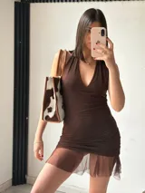 Vestido corto color marrón, con escote halter, espalda descubierta, corte ajustado y falda con volados.
