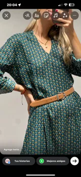 Vestido largo de mangas largas con estampado floral en tonos verde y marrón. Tiene cuello en V y cinturón marrón.