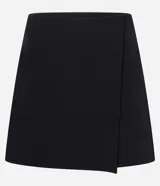 Short pollera negro de crepé con diseño cruzado, bolsillos traseros y pinzas.