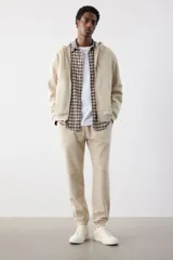 Pantalón de jogging color beige, de corte recto, con cintura elástica ajustable con cordón y puños acanalados.