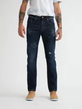Jean slim fit de color azul oscuro con detalles de desgaste y costuras decorativas.