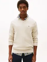 Sweater color beige de Tommy Hilfiger, de corte clásico, con cuello en V y logo bordado en el pecho.