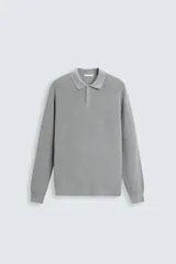 Polo gris de punto tejido en hilatura de algodón, corte relaxed fit, cuello solapa con cierre frontal de botonadura, manga larga y acabados en rib.