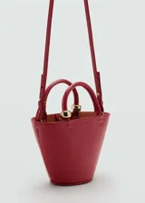 Bolso rojo con efecto piel, forma trapezoidal, asa de mano rígida, asa larga desmontable tipo bandolera y cierre de mosquetón.