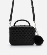 Bolso transversal tipo camera bag, color negro, hecho en material sintético texturizado. Tiene correa fina ajustable y removible, cierre por cremallera y colgante pompón.