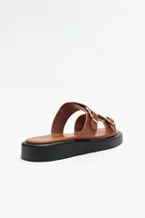 Sandalias marrones con plataforma baja y tiras anchas con hebillas metálicas.