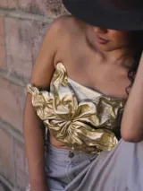 Top sin mangas, color dorado, confeccionado en cuero genuino con diseño fruncido y estructurado en el frente.