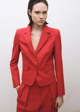 Blazer rojo con solapas de muesca, cierre frontal con dos botones y bolsillos delanteros con solapa.