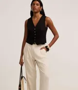 Pantalón zanahoria de cintura alta color borgoña, con trabillas, pliegues y cinturón fino de cuero sintético.