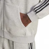 Canguro Adidas Adicolor gris melange con cierre frontal, capucha con cordón de ajuste y bolsillos laterales. Presenta las tres tiras características de la marca en color negro a lo largo de las mangas y el logo bordado en el pecho.