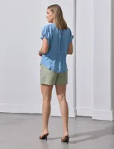 Blusa celeste de lyocell, con cuello a la base y escote en V. Manga corta con detalle de punto smock. Marca Zac & Rachel.