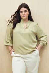 Camisa celeste de manga larga en viscosa suave, con cuello mao y botonadura parcial al frente. El detalle de frunces en los hombros y los puños abotonados le suman delicadeza y estilo.