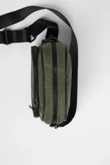 Bandolera verde militar con correa ancha negra ajustable.