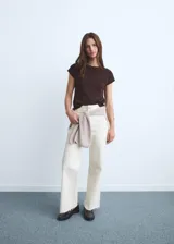 Pantalón de jean tiro alto, color blanco crudo, corte culotte con bajo deshilachado.