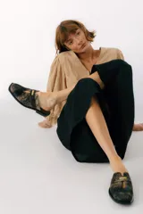 Zuecos con estampado animal print en blanco y negro, con tira ancha de cuero negro y aplique metálico.