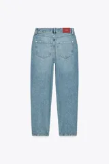 Pantalón de jean celeste de corte mom fit, tiro alto, largo tobillero y cinco bolsillos.