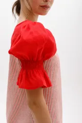 Vestido corto con cuerpo a rayas verticales en tonos beige y blanco, mangas cortas abullonadas y canesú superior en color negro.