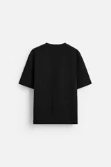 Camiseta negra de corte holgado, con cuello redondo y mangas cortas.