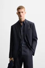 Blazer azul marino de lino, corte regular fit, con solapas de muesca, cierre de dos botones, bolsillo de vivo en el pecho, bolsillos de solapa en la cadera, aberturas en la espalda y puños con botones.