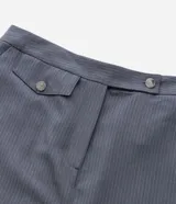Pantalón de vestir gris oscuro con estampado de raya diplomática, corte recto, cintura alta con elástico en la parte trasera, bolsillos laterales y cierre frontal con botón y cremallera.