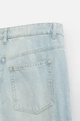 Pantalón cargo de denim color beige, corte relaxed fit, con bolsillos laterales tipo parche con solapa y cierre frontal con botones.