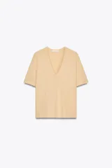 Camiseta color beige de lino con cuello en V y mangas cortas.