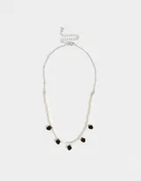 Collar corto de perlas blancas con dijes de rosas rojas.
