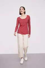 Remera de manga larga entallada en color blanco, confeccionada en algodón. Presenta cuello redondo con una hilera de botones frontales y un pequeño bolsillo en el pecho con detalle de botón.