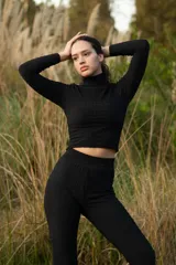 Polera corta negra de cuello alto confeccionada en jersey fantasía.