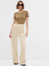 Pantalón de jean color beige, de tiro alto y corte wide leg.