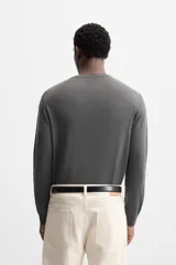 Jersey negro de lana con acabado mercerizado, corte relaxed fit, cuello redondo y manga larga con terminaciones en rib.