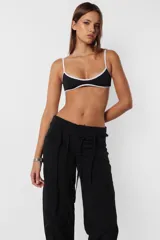 Pantalón de vestir gris, de corte recto y tiro medio. Presenta detalle de falsa cintura con presillas y cinto tira incluido.
