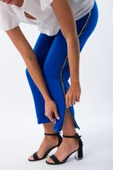 Pantalón azul eléctrico de corte cigarette, con bolsillos laterales y cierre lateral con cremallera plateada desde el tobillo hasta la cintura.