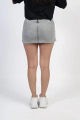 Minifalda gris de jean con diseño cruzado y tachas plateadas.