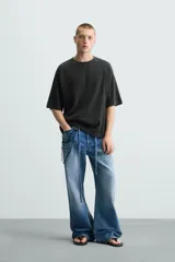 Camiseta negra de corte holgado, cuello redondo y mangas cortas. Tiene un efecto de lavado que le da una apariencia única.