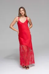 Vestido largo de seda color rojo, con escote en V y breteles finos. Presenta detalles de encaje en el escote y un diseño asimétrico en la falda que incorpora encaje transparente desde la altura de la rodilla.