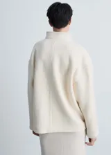 Chaqueta color crema de mezcla de lana con cuello alto y cierre de botones oculto.