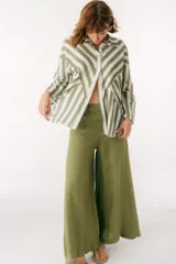 Camisa celeste y blanca a rayas verticales, de corte holgado y mangas largas.