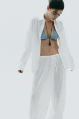Pantalón bombacho de algodón blanco, con tiro medio, cintura elástica ajustable con cordones y bajo abullonado con elástico.