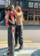 Pantalón de jean gris oscuro con corte recto y bolsillos traseros con apliques de estrellas rojas.