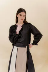 Blusa negra de lino con mangas balloon y detalle de tablón en el hombro. Tiene mangas largas con detalle de dos pespuntes elásticos en contratono.